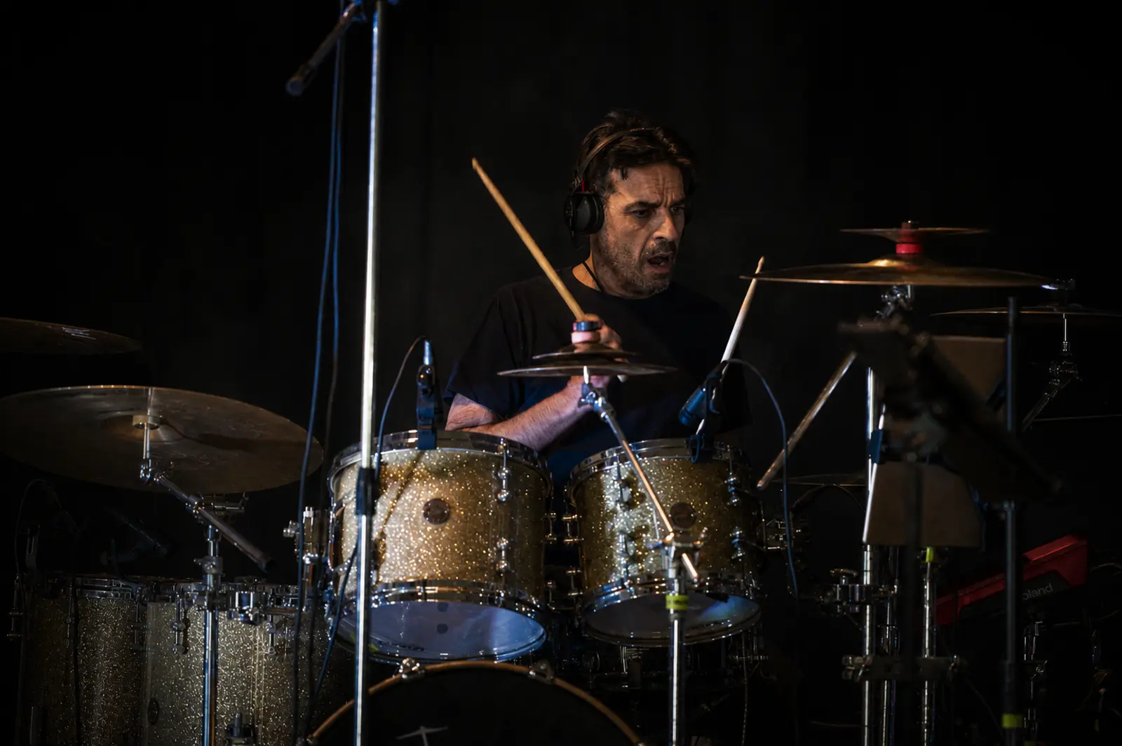 Drummer playing a sparkle gold drum kit on stage