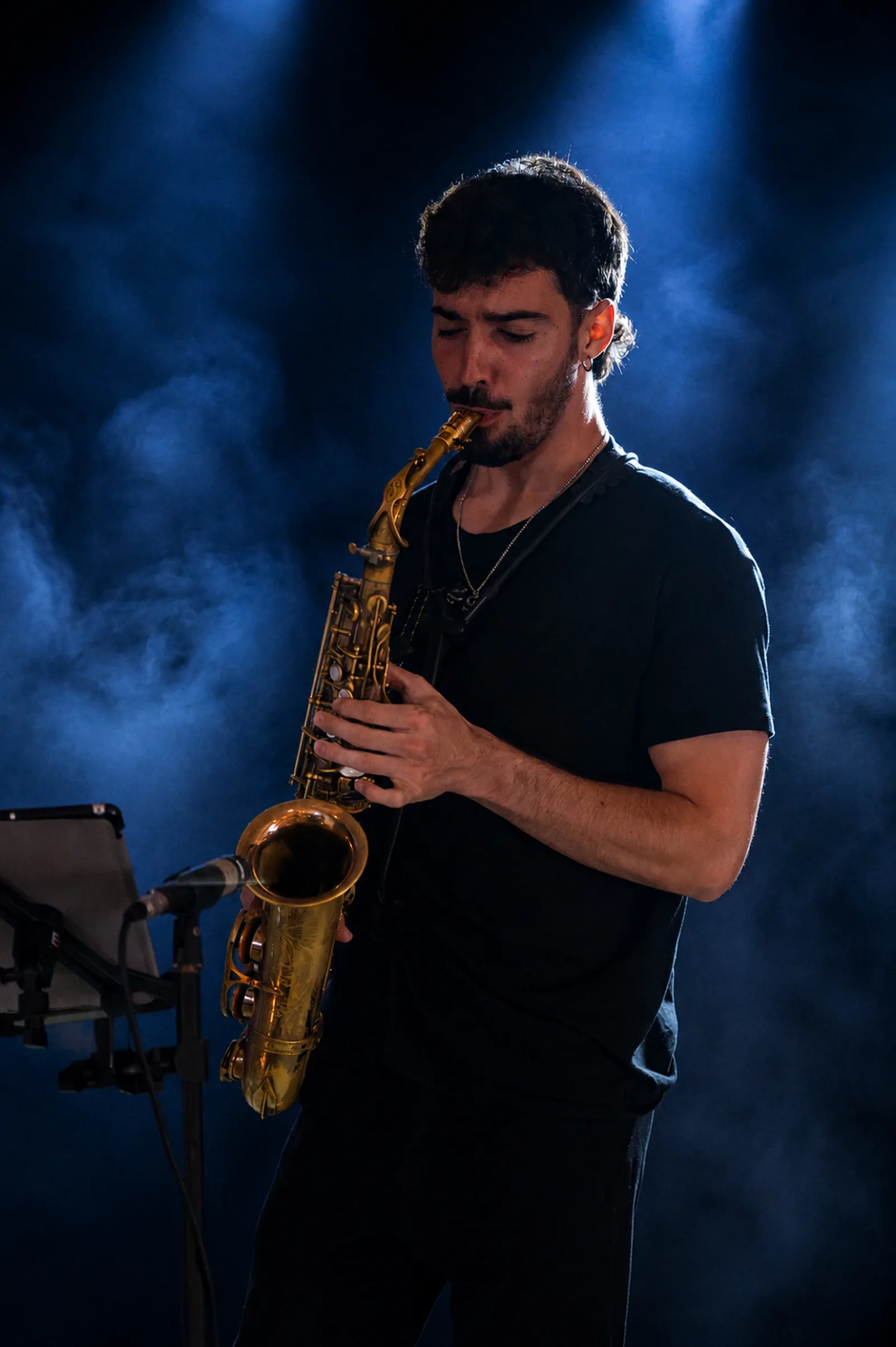 Saxophone player Martí Cabarrocas performing on stage under blue spotlight
