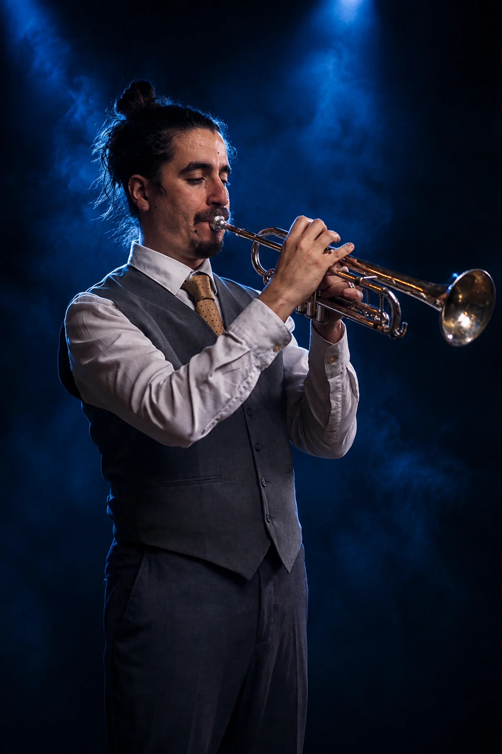 Trumpet player Albert Clapés performing on stage under blue spotlight