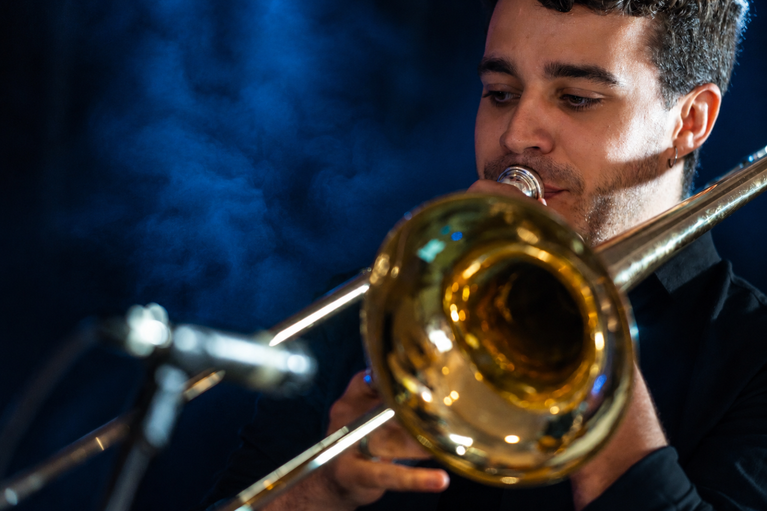 Trombone player Ferran Reig performing on stage under blue stage light